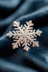 Poster - A finely detailed snowflake is delicately positioned on a dark blue velvet surface. Soft shadows and warm lighting enhance the luxurious winter aesthetic, showcasing its intricate design