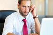 © Minerva Studio - Stressed businessman having headache while working on laptop in office