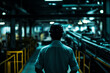 © ivlianna - Factory worker observes assembly line operations during evening shift in industrial setting