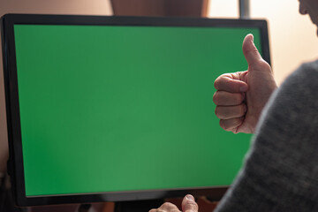 Aufkleber - Closeup of man working on computer with blank chromakey screen workspace area and showing thumb up, Man greeting someone while sitting at a computer, captured from behind in a close-up