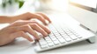 © KamStudio - Close-up of hands typing on a sleek desktop keyboard in a modern office, with clean lines, soft natural lighting, and an elegant workspace reflecting remote work culture.