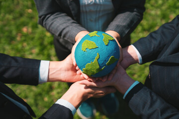 Wall Mural - Group of business people hold planet Earth globe together as Earth day concept. Mission to save Earth by business commitment to environment friendly methods and sustainable practices. Gyre