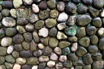 The oval shaped river stones used as ornaments on the outer walls of the house fence