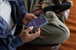 © ReeldealHD images - Over the shoulder view of man checking financial data with mobile banking app on a smartphone