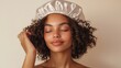 © timurlan999 - Young woman wearing a silver satin bonnet for healthy hair care routine