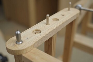 Close up of wooden object with smooth surface, metal pegs, and natural wood grain