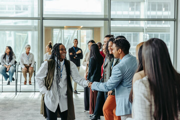 Wall Mural - Greetings among a diverse group of professionals during a casual business meeting in a modern office space with natural lighting and positive energy