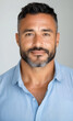 © Artificial South - Confident Man Portrait: A headshot of a middle-aged man with a warm, friendly smile, showcasing his confidence and approachability. He has salt-and-pepper stubble and dark eyes.