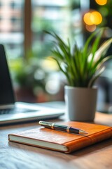 Poster - Focused Workspace: Leather Notebook, Pen, Laptop, and Plant on a Wood Desk with a Blurred Background, Creating a Productive and Serene Office Environment