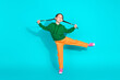 © deagreez - Cheerful young girl in colorful outfit posing against a bright turquoise background