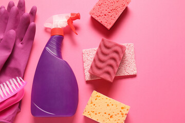 Wall Mural - Spray bottle of cleaning product and tools on pink background, flat lay