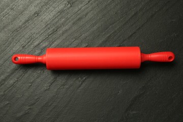 Wall Mural - Red rolling pin on dark gray textured table, top view