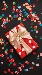 Sticker - Extreme close up of a gift box wrapped in shiny paper and a big bow, surrounded by sparkling confetti, glittering decorations, and a New Year's Eve theme.