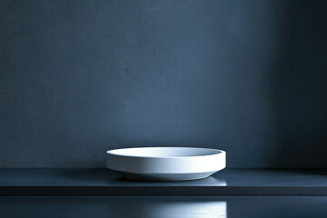 Aufkleber - A minimalist white bowl sits on a dark blue surface against a textured wall, creating a serene and simple scene.