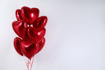 Wall Mural - Heart-shaped red balloons on light background, space for text. Valentine's day