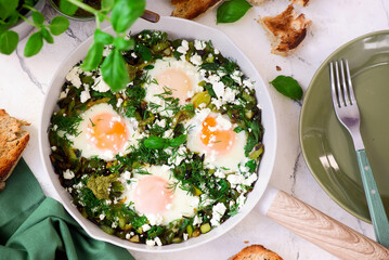 Wall Mural - Green shakshuka with feta, pesto and crispy bread.traditional moroccan dish. selective focus. hugge style