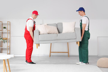 Wall Mural - Loaders carrying grey sofa in stylish room