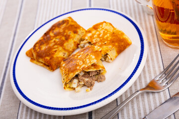 Delicious pancakes stuffed with liver and egg served on platter for breakfast