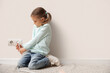 © Pixel-Shot - Cute little girl inserting plug into socket at home. Child in danger