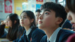 © Oppilamani - Group of Chinese Students in Uniform, Attentively Listening to Their Teacher in a Classroom, Highlighting Engaged Faces and Colorful Educational Materials on the Walls