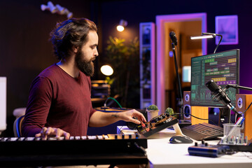 Leinwandbilder - Sound engineer mixing and mastering new songs in home studio, adding piano electronic keyboard tunes. Young talented producer composing music with stereo equipment and synthesizer.
