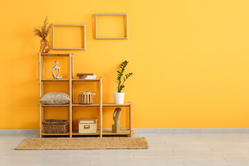 Wall Mural - Shelving unit and empty photo frames on yellow wall