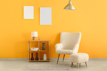 Wall Mural - Armchair and shelving unit with empty posters on yellow wall