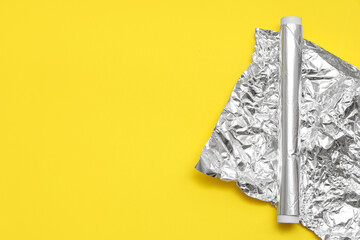 Canvas Print - Aluminium foil roll with crumpled sheet on yellow background