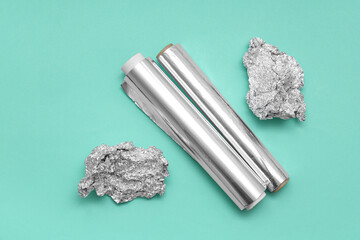 Canvas Print - Aluminium foil rolls with crumpled sheets on turquoise background