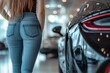 © EUT - Woman in blue jeans near a luxury car. Illustrates aspiration, success, and style.