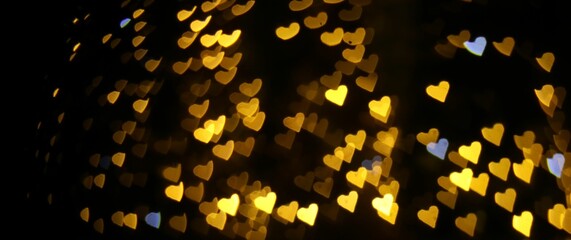 Sticker - Romantic decor. Blurred view of heart shaped lights on black background, bokeh effect