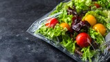 Fresh salad mix in clear plastic bag on dark surface