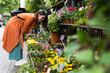 © BUDDHA - Smiling woman choosing flowers in market