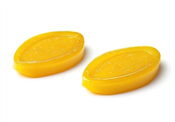 Two yellow oval hard candies on white background