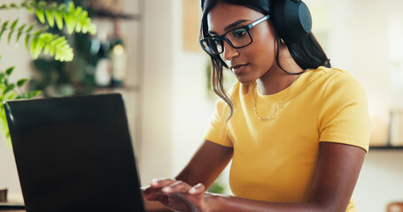 Poster - Laptop, music and typing with Indian woman in home office as graphic designer for marketing campaign. Computer, headphones and remote work with freelance employee in apartment for publication