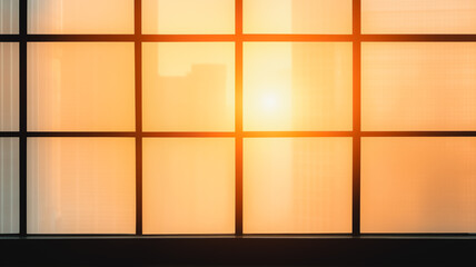 Poster - Golden Hour Through Window Pane: A warm and inviting glow fills the room as sunlight streams through a large window pane with delicate grid lines, casting a soft, diffused light.