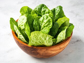 Wall Mural - A wooden bowl filled with fresh Romaine lettuce, showcasing the bright green color and crisp texture of this healthy leafy vegetable. Perfect for creating nutritious salads.