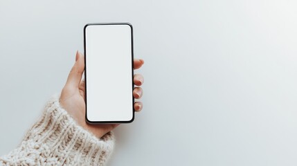 A woman's hand holds a blank smartphone with a white screen isolated on a white background. Template concept with copy space