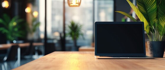 Wall Mural - Laptop on cafe table, blurred background, plants