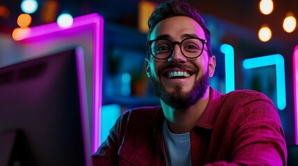 Poster - Man with glasses is smiling and looking at the camera. He is sitting in front of a computer monitor