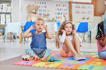 Aufkleber - Education, children and song in classroom for learning, growth and sensory development. Kids, touch ears and lesson at elementary school for creativity, following instruction and listening exercise