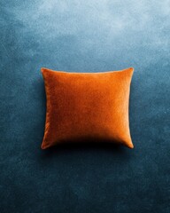Wall Mural - orange velvet pillow on textured blue background for decor