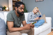 © Srdjan - Gadget addiction and relationship problems. Couple with smart phones ignoring each other. Obsessed man and woman, roommates with their cell phones ignore each other sitting on a couch at home.