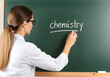 © Rohit k  - Teacher writing chemistry on blackboard, chalking during classroom lesson, educational setting with academic learning background
