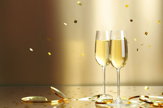 Wall Mural -  - champagne in glasses and flying confetti on golden background, space for text