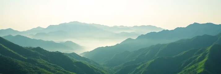 Poster - Layers of lush green mountain ranges create a breathtaking vista, shrouded in a delicate mist as the sun gently rises, casting a soft glow over the tranquil landscape