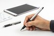 © jay - Hand Holding Silver Pen for Handwriting and Drawing on White Desk with Digital Tablet