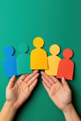 Poster - Colorful paper cutouts representing diverse people held in hands. Ideal for teamwork, diversity, and community concepts.