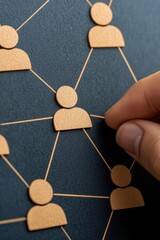Poster - A hand connecting wooden figures on a dark background, symbolizing networking and collaboration in professional environments.