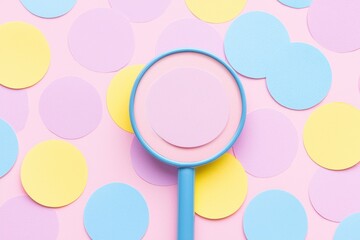 Poster - a vibrant top view of colorful circles with a magnifying glass highlighting a pink circle, creating 